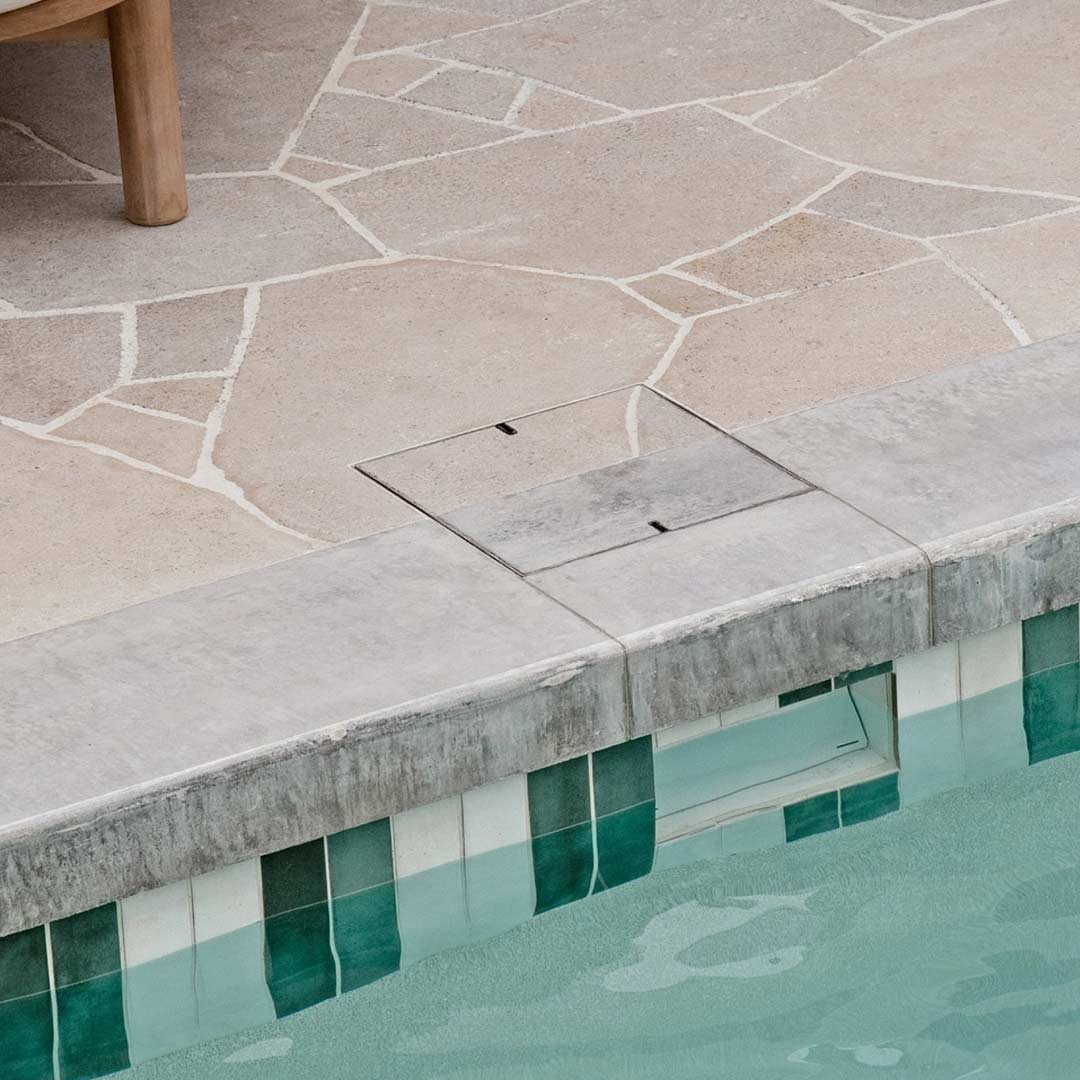 HIDE Concrete Skimmer Lid with dual concrete and crazy pave inlay installed next to modern swimming pool.