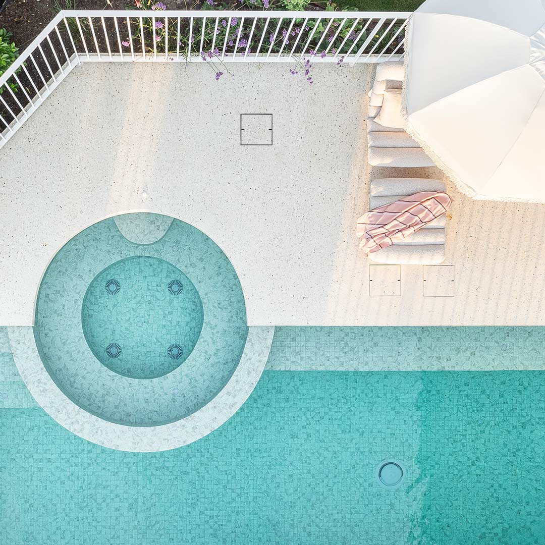 HIDE Wet-pour concrete covers installed next to modern curved swimming pool