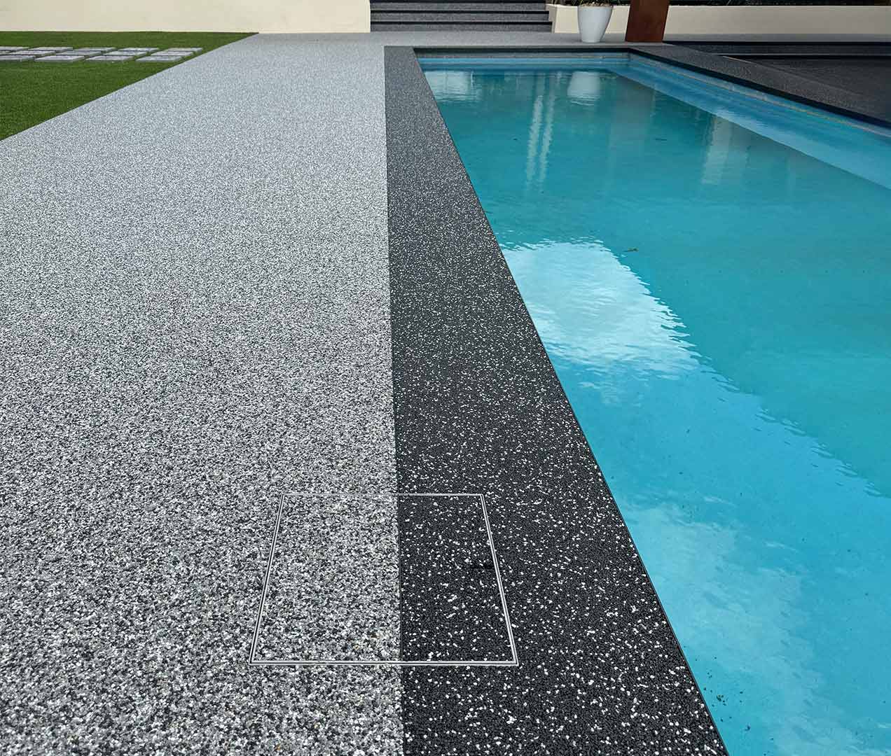 HIDE Concrete Skimmer Lid with quartz resin dual inlay installed next to swimming pool.