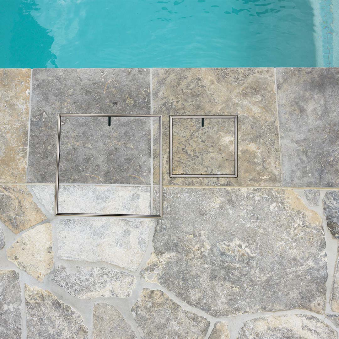 HIDE Bone Combination Skimmer Lid and Access Cover with non-conductive polymer frame and stainless steel lid, set flush into poolside paving for a seamless finish. Access Covers - Hybrid Kits