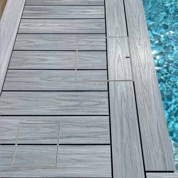 HIDE Ash Full Polymer Skimmer Lid and matching Access Cover integrated into poolside composite decking for a seamless, non-conductive finish.